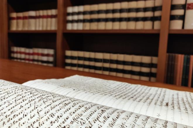 Detail of a document and bookcase with catalogues stored in the Historical Archives of the Jesuit Euro-Mediterranean Province in Rome