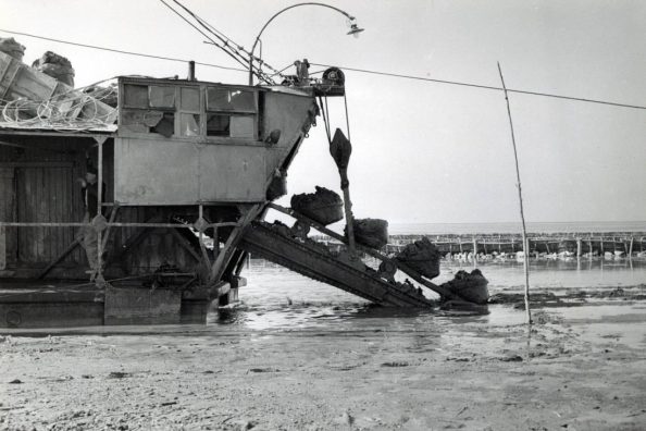 Foto di un mezzo meccanico al lavoro per rimuovere il fango dell'alluvione nel Polesine - Archivio Storico - Gesuiti, Provincia Euro-Mediterranea